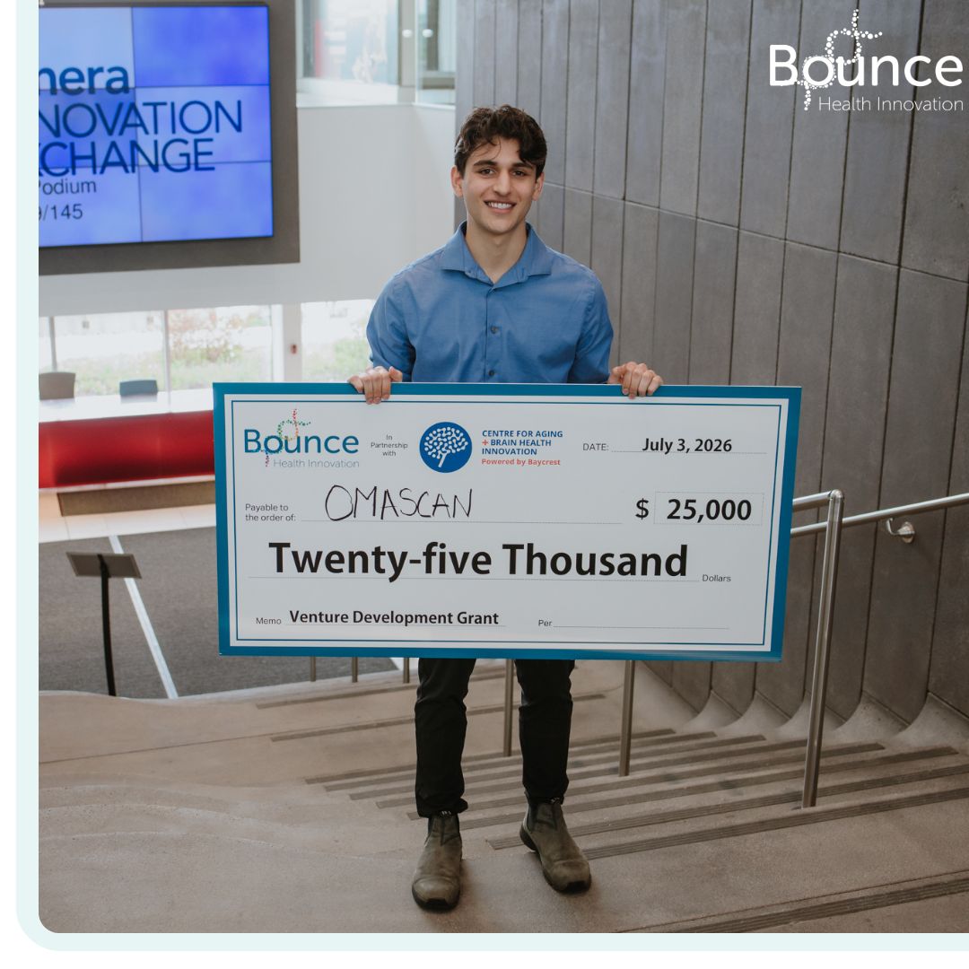 An OmaScan team member holding a $25,000 venture development grant cheque from Bounce Health Innovation and the Centre for Aging and Brain Health Innovation