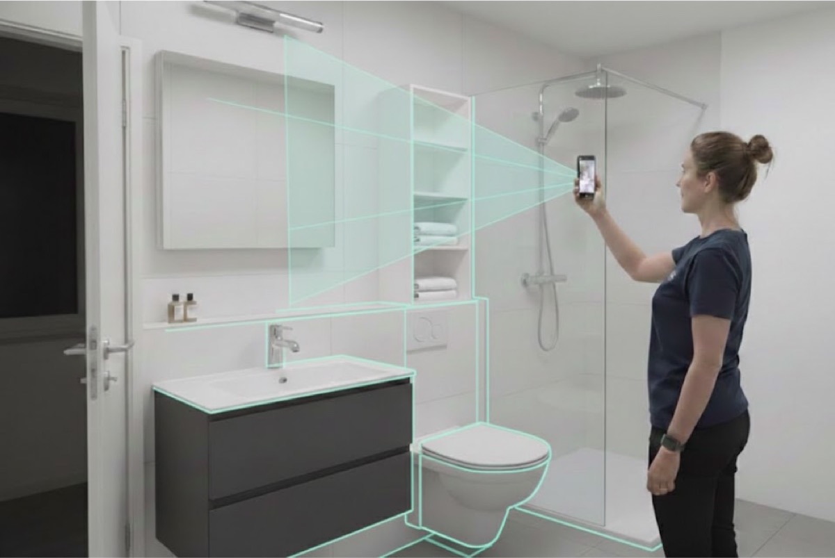 A client capturing her bathroom with her phone, with the room outlined on screen as she scans
